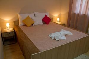 a bedroom with a large bed with two lamps at Garni Hotel Tri O in Kragujevac