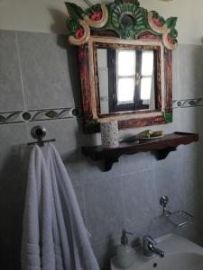 baño con lavabo, espejo y toalla en Guesthouse Filokalia, en Portaria