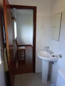 a bathroom with a sink and a mirror at Hospedaria Lampião in Penacova