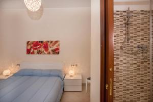 a bedroom with a blue bed and a shower at B&B Villa Aurora in Brugherio