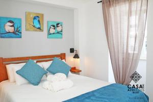 a bedroom with a bed with towels on it at Casa do AZULejo - Blue in Peniche