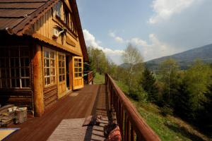 a large wooden deck next to a cabin with a view at Tarnasówka w Szczyrku in Szczyrk