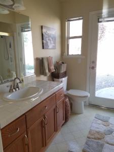 ein Badezimmer mit einem Waschbecken, einem WC und einem Spiegel in der Unterkunft Oak Retreat by Yosemite National Park in Coarsegold