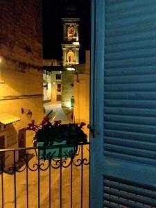 een tafel op een balkon met een klokkentoren op de achtergrond bij Dimora del Castellano in Gioia del Colle