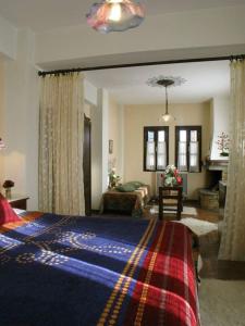 - une chambre avec un lit et un salon dans l'établissement Guesthouse Filokalia, à Portariá