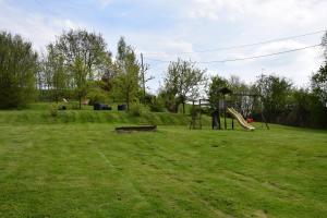 un parque infantil con un tobogán en un campo de césped en B&B La ferme de Berwausault en Herve