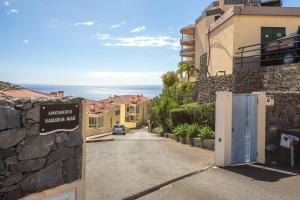 a street in a town with a gate to a villa at Peace Haven in Calheta