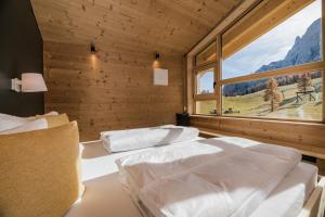 two beds in a room with a large window at Rotwandwiesen Chalets SKI IN/OUT - 1900mt in Sesto