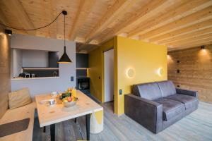 a living room with a couch and a table at Rotwandwiesen Chalets SKI IN/OUT - 1900mt in Sesto