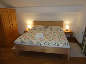 1 cama en un dormitorio con 2 lámparas en 2 mesas en Ferienwohnung Fuchs, en Bad Mitterndorf