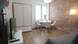ein Wohnzimmer mit einem Tisch und einer Ziegelwand in der Unterkunft Apartament Akali in Kielce