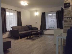 ein Wohnzimmer mit einem Sofa und 2 Fenstern in der Unterkunft Apartament Nad Kamienną 2 in Jelenia Góra