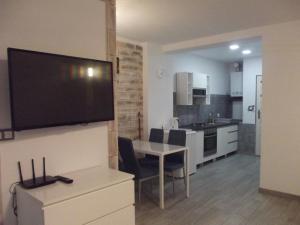 a kitchen and dining room with a flat screen tv on a wall at Apartament Nad Kamienną 2 in Jelenia Góra