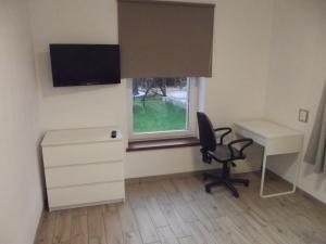 a bedroom with a desk and a chair and a window at Apartament Nad Kamienną 2 in Jelenia Góra