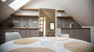 a kitchen with a white table and chairs and a kitchen with blue tiles at Apartmán Veritas in Mikulov