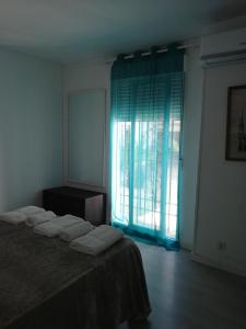 um quarto com uma cama e uma grande janela em Apartamento En Los Patios De San Basilio em Córdoba