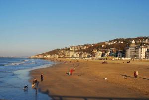 a group of people on a beach near the ocean at Villa Classée 4 étoiles Vue mer exceptionnelle in Trouville-sur-Mer