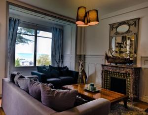 sala de estar con sofá y chimenea en Villa Classée 4 étoiles Vue mer exceptionnelle en Trouville-sur-Mer