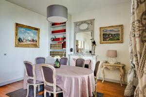 a dining room with a table and chairs and a mirror at Villa Classée 4 étoiles Vue mer exceptionnelle in Trouville-sur-Mer +11 photos