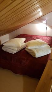 a bed with three pillows on it with a red bed at Ojuspirtti 26B Levi in Levi