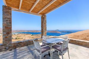 a table and chairs on a deck with a view of the ocean at Serifos Blue in Rámos