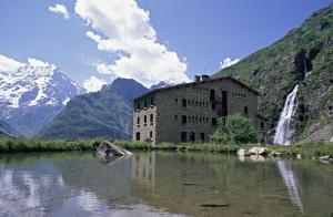 an old building in the middle of a river with a waterfall at Chez Angie et Fanny - Résidence l'Horizon Blanc in La Joue du Loup