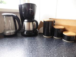 una macchinetta del caffè su un bancone accanto a due sgabelli di Beemster Oase a De Beemster