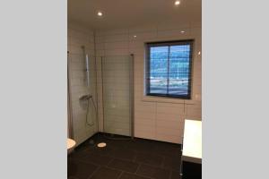 a bathroom with a shower and a window at Balestrand Fjordapartments Holmen 19A in Balestrand +54 photos