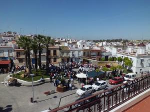 una multitud de personas de pie alrededor en una ciudad en NOVO Apartahotel & Restaurante, en Las Cabezas de San Juan