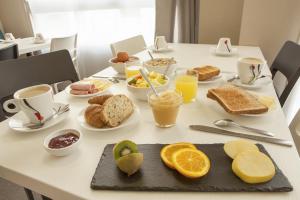 a table with breakfast foods and drinks on it at Hôtel Novella Nantes Centre Gare in Nantes