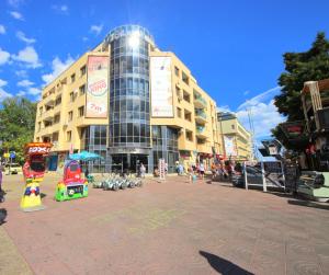 a building on a city street with people in front of it at Menada Midia Apartments in Sunny Beach