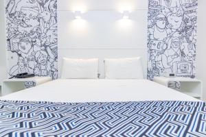 a bedroom with a white bed with a patterned wall at ibis Styles Rio de Janeiro Botafogo in Rio de Janeiro