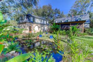 a house with a pond in front of it at The Cottage at DuPont in Charleston