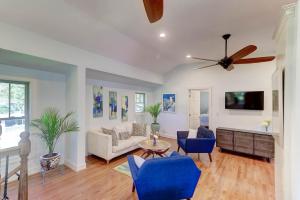 a living room with blue chairs and a ceiling fan at The Cottage at DuPont in Charleston