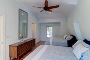 a bedroom with two beds and a ceiling fan at The Cottage at DuPont in Charleston