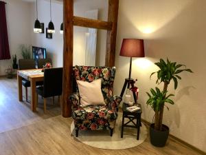 a living room with a chair and a table at Schöne Ferienwohnung am Mathildenbrunnen in Quedlinburg