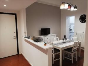 a kitchen with a white counter and a table with chairs at Davide & Mary friendly house in Novara