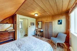 1 dormitorio con 1 cama y 1 silla en una habitación en Dunrovin Vintage Beach Cottage - 1 Bed 1 Bath Vacation home in Port Orford, en Port Orford