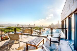 einen Balkon mit Stühlen und einem Tisch auf einem Gebäude in der Unterkunft Monsieur Jean - Hôtel Particulier in Québec