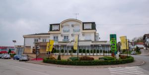 a building on a street with cars parked in front of it at Hotel Integra in Doboj