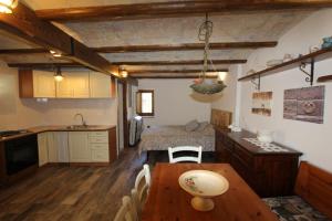a kitchen with a table and a bed in a room at Monolocale rustico in Cansano