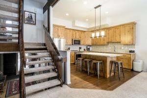 a kitchen with wooden cabinets and a kitchen island at Moraine 27 Townhouse near Gondola in Steamboat Springs