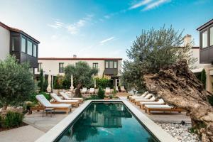a swimming pool with lounge chairs and a house at Bernadet Alaçatı in Alaçatı