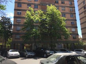 a tall building with cars parked in a parking lot at Departamento Centrico travel & business in San Salvador de Jujuy