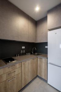 a kitchen with wooden cabinets and a white refrigerator at Belly2 in Vračar (historical) +7 photos