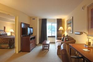 a hotel room with a bed and a living room at Staybridge Suites North Brunswick, an IHG Hotel in North Brunswick