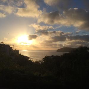 um pôr-do-sol sobre o oceano com o sol no céu em Casa Calanave 1 em Ventotene