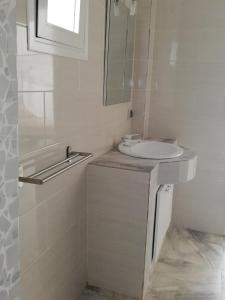 a white bathroom with a sink and a mirror at Villa Roka - Toubab Dialaw in Toubab Dialaw