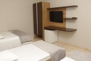 a room with two beds and a flat screen tv at MATIZZE HOTEL in Marabá +17 photos