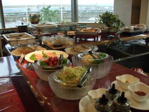 a buffet line with bowls of food on a table at Business Hotel Ekimae in Hakodate